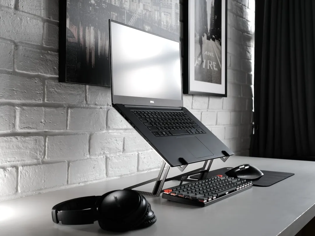 Portátil elevado sobre un soporte plegable delgado en un escritorio