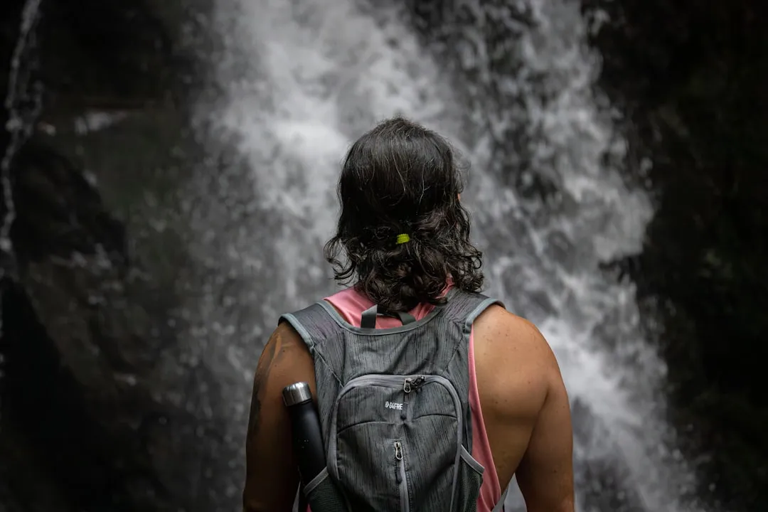 Botella de agua reutilizable junto a una mochila de senderismo al aire libre